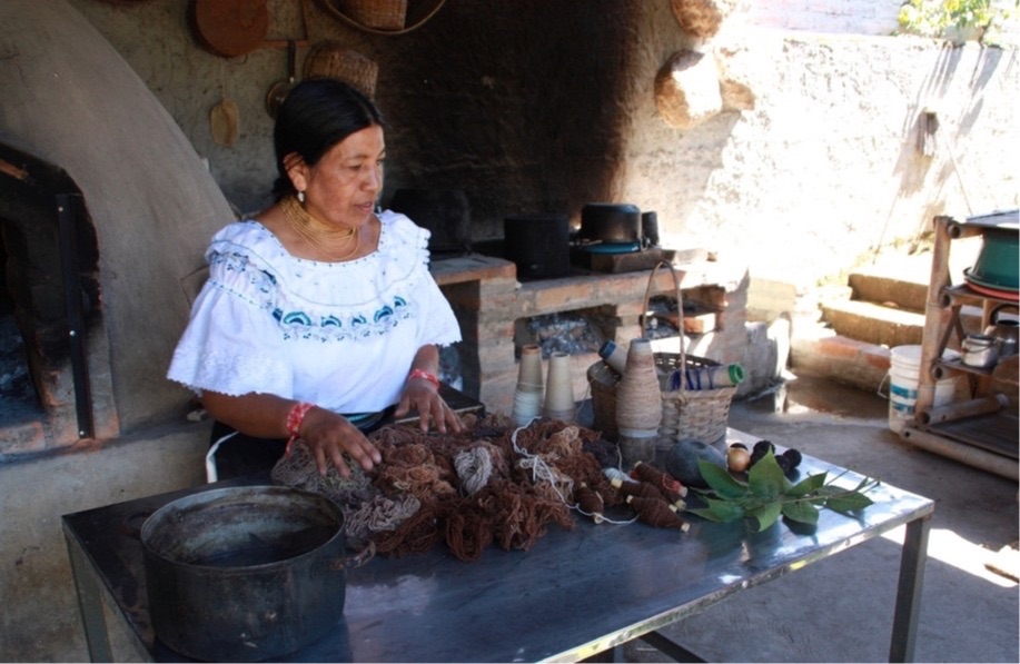 Indigene Köchin bereitet Speisen im Lehmofen in Otavalo